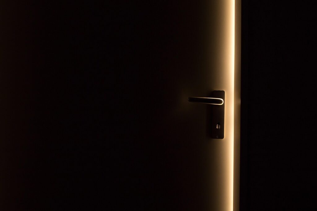 A dark door opening toward light, symbolizing uncertainty ahead of the Fed's interest-rate decision.