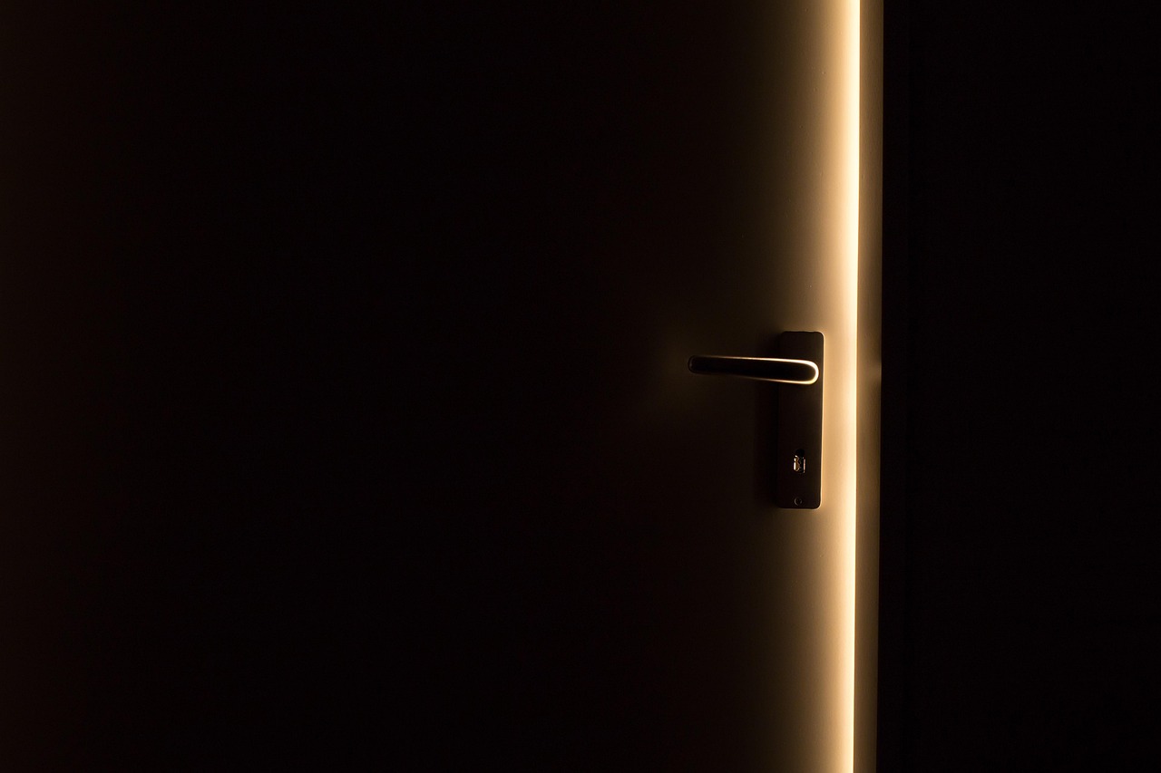 A dark door opening toward light, symbolizing uncertainty ahead of the Fed's interest-rate decision.
