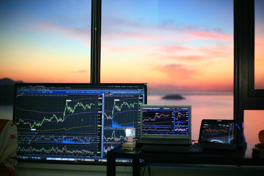 Stock market trading charts on monitors at sunrise, symbolizing the S&P 500 rising over the long term