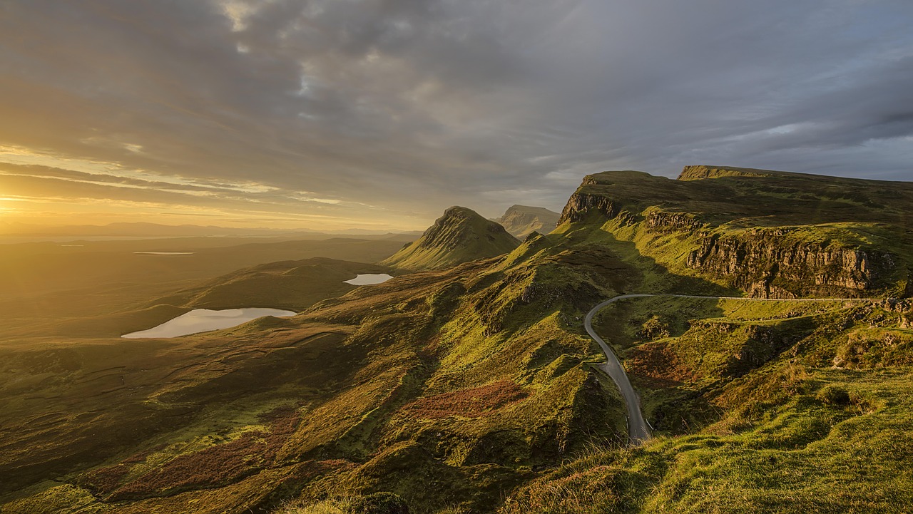 A winding mountain road at sunset, symbolizing the slow and steady long-term investing journey.