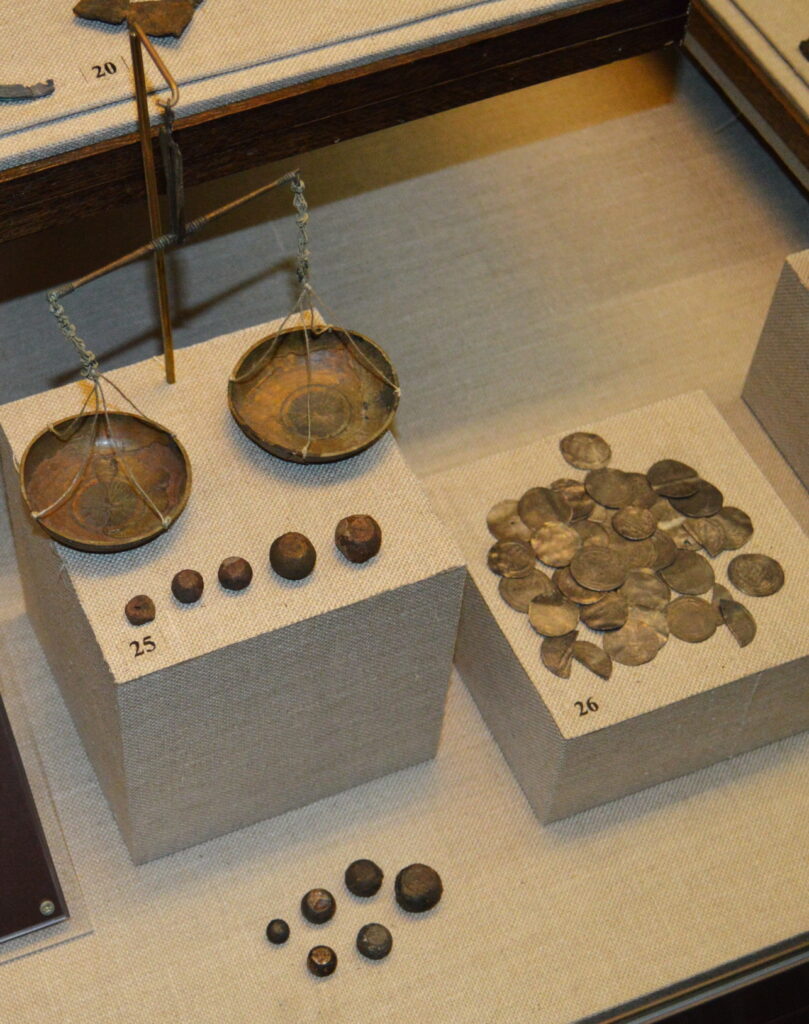 Old brass balance scale weighing coins, symbolizing purchasing power balanced against inflation over time
