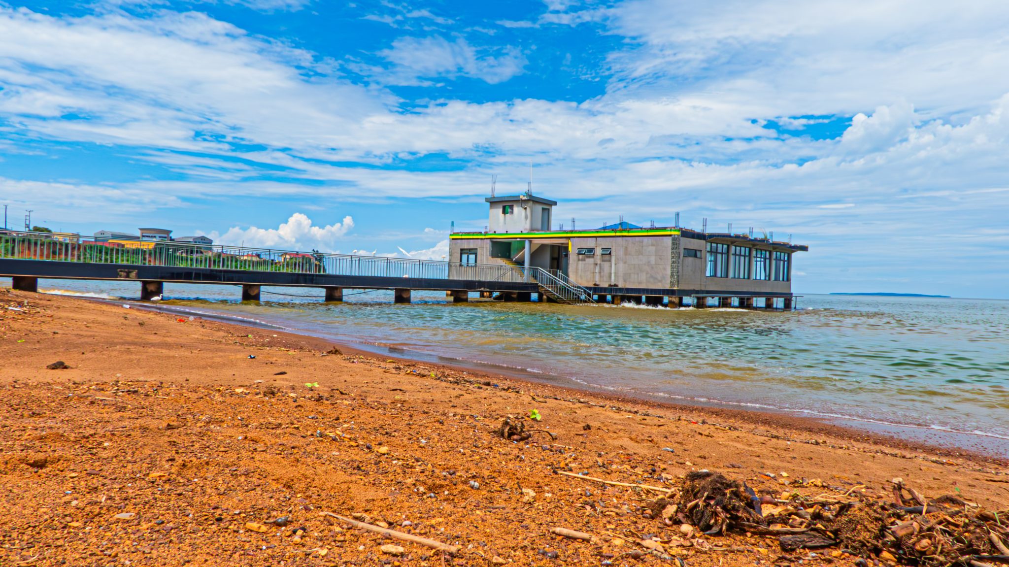 A long concrete pier stretching toward the ocean horizon, illustrating how something anchored further away feels the effect of a small push much more than something close by.