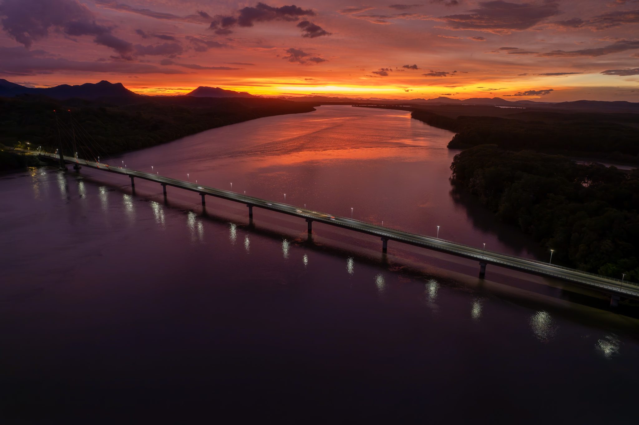 A long bridge stretching toward a distant horizon at sunset, symbolizing long duration