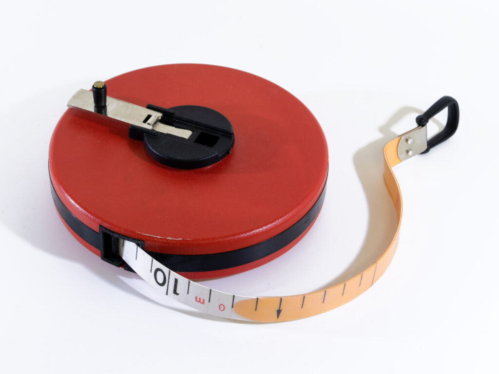 A retractable steel tape measure extended across a surface, symbolizing the concept of duration in bond investing.