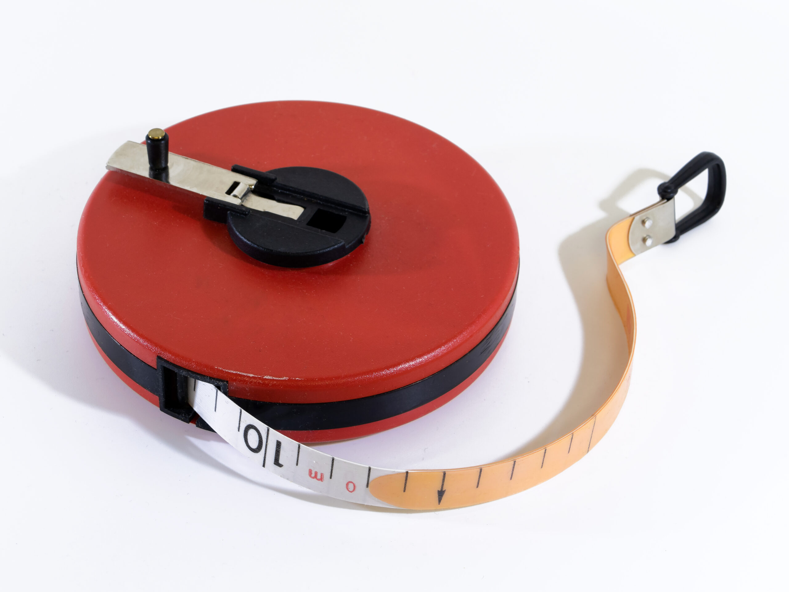 A retractable steel tape measure extended across a surface, symbolizing the concept of duration in bond investing.